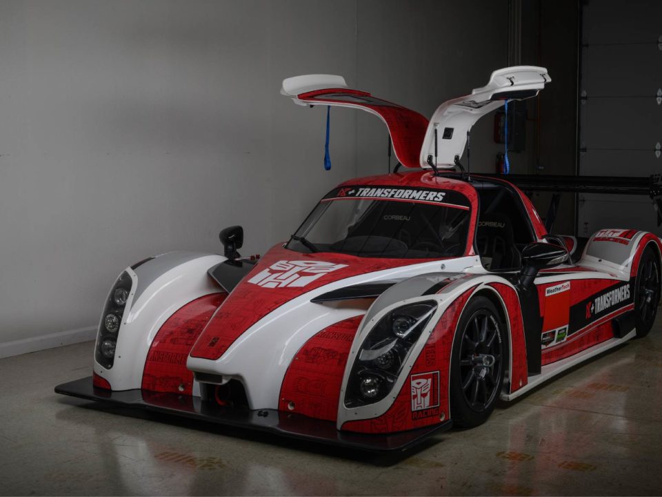 A red and white race car with open doors.