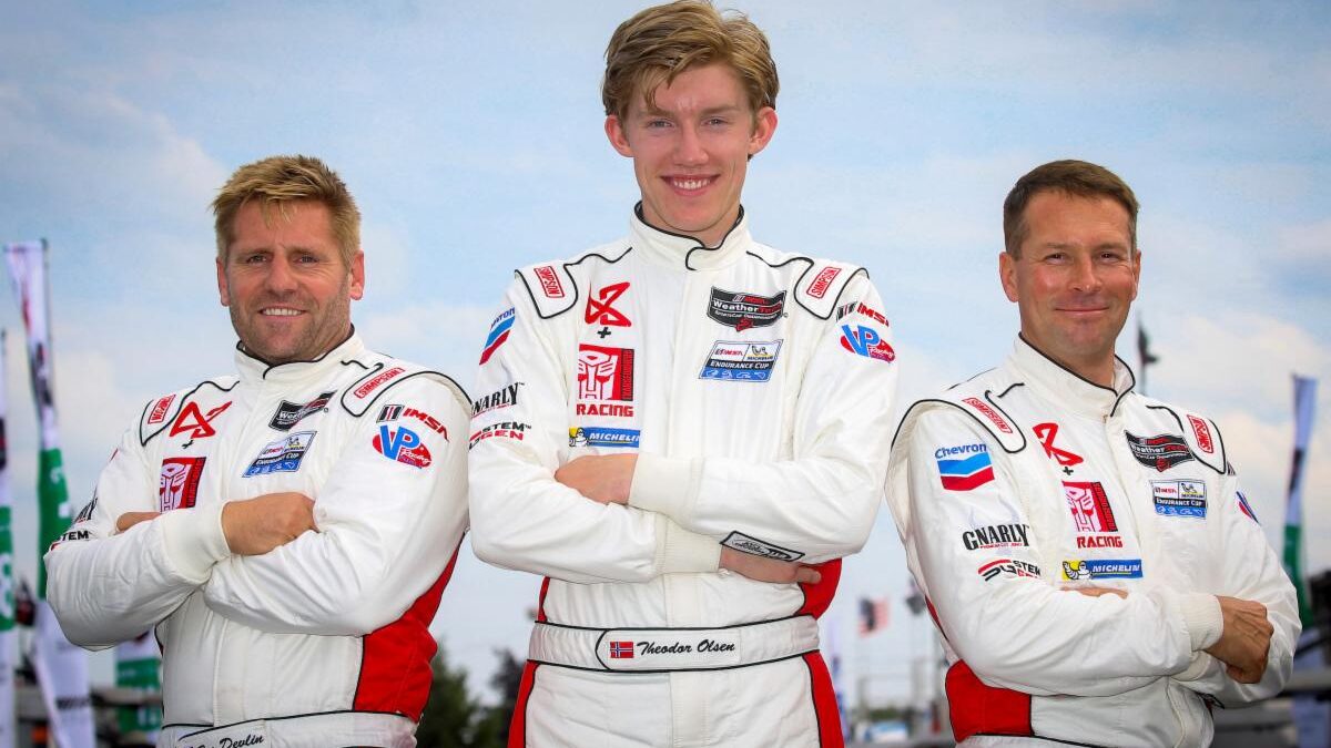 Three men in racing suits posing for a picture.