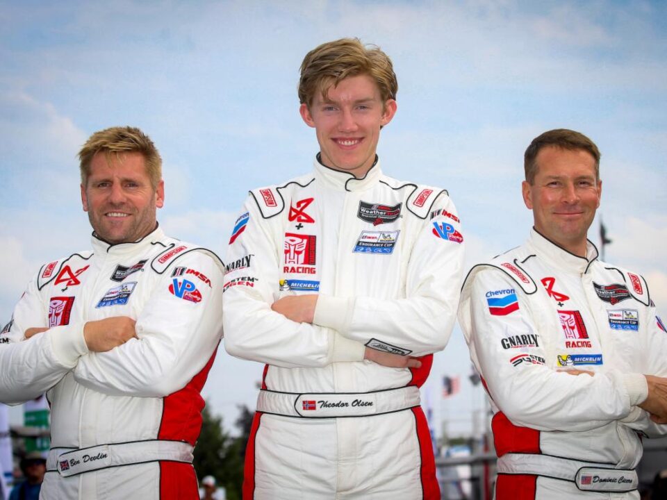 Three men in racing suits posing for a picture.